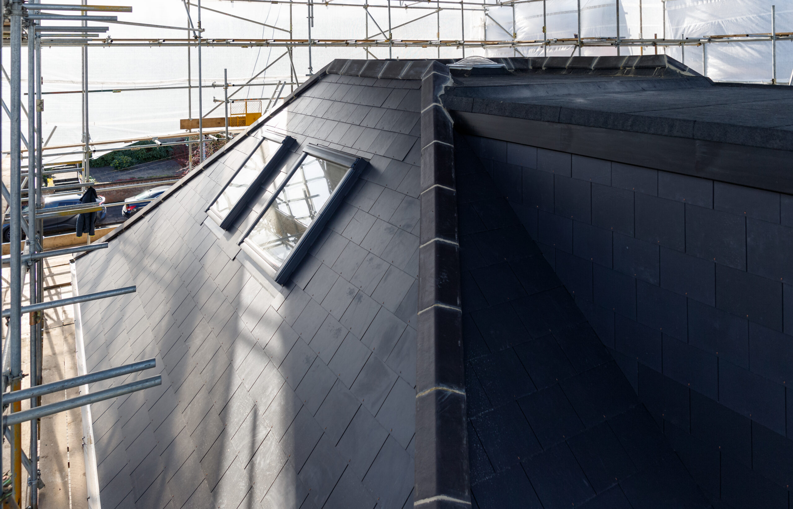 Edge of a new roof showing Velux windows and grey tiles